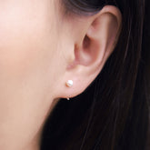 Fine jewellery, silver jewellery, hypoallergenic, tarnish-free, Close-up of an ear wearing a silver pearl stud earring with a blurred background